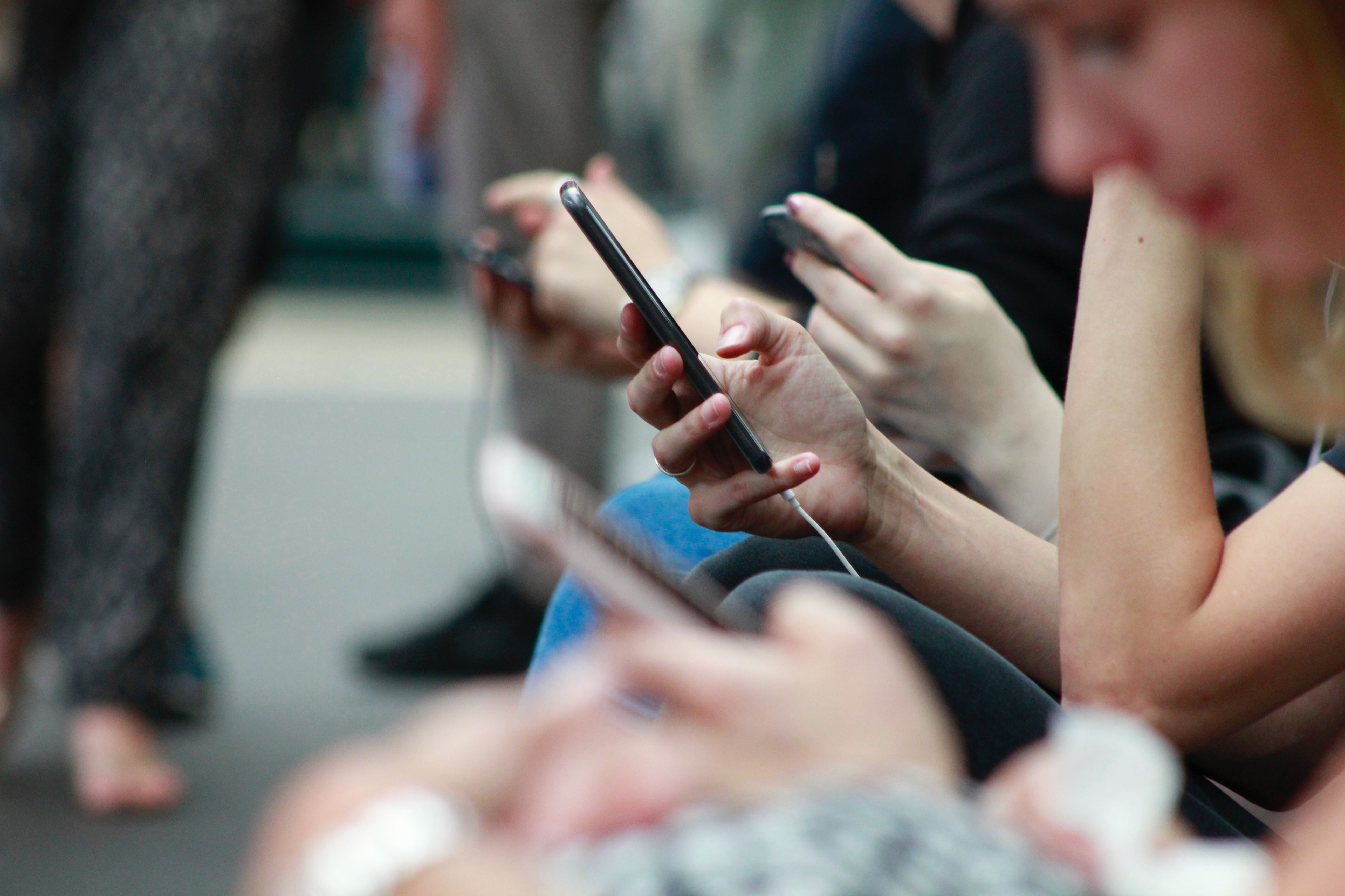 People browsing their phones while waiting for a train