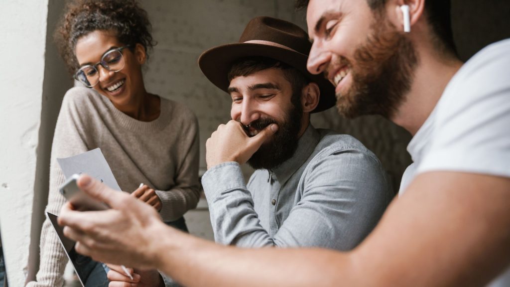 Group of young employees working safely together on different devices